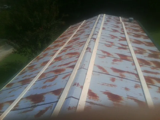 Rusted metal roof panels with new wood purlins before replacement — Storm Damage Roof Repair in Waterman by Roofing Brothers