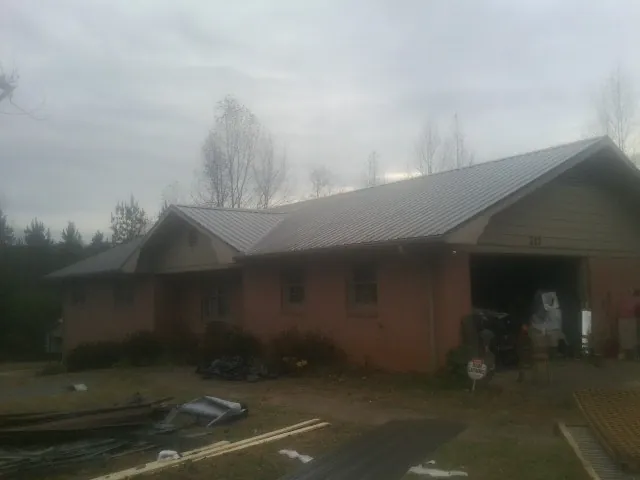 Gray metal roof on a stucco house with an attached garage in Waterman
